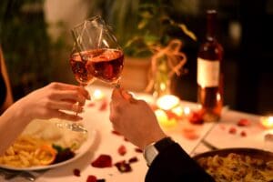 A person holding a wine glass at a table