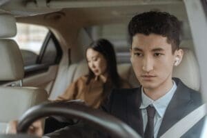 A man and woman in the back of a car.