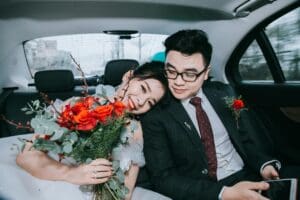 A man and woman sitting in the back of a car.